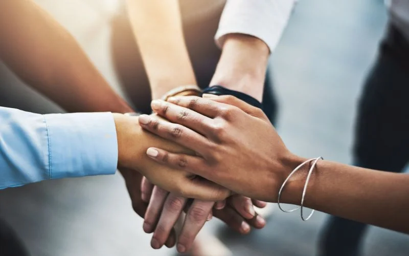a-group-of-business-people-with-their-hands-on-top-of-each-other