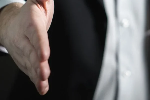 a sales-training-person-in-suit-is-holding-out-their-hand